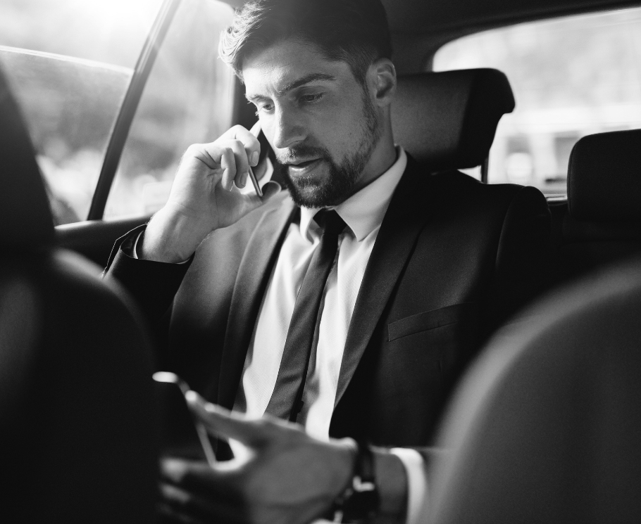 Homme d'affaires en costume téléphone dans sa voiture.
