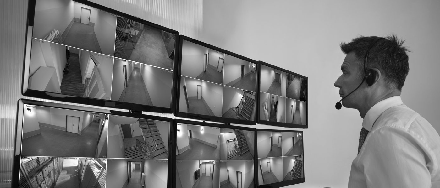 Un homme devant un mur d'images de surveillance